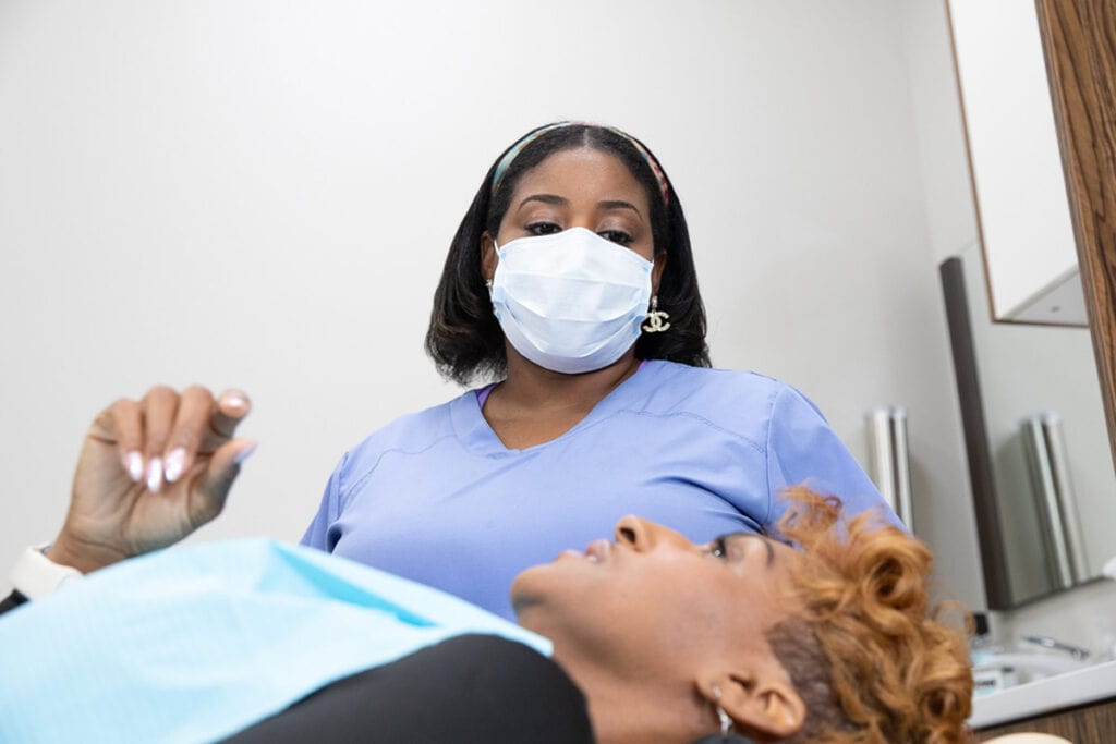 Dental Assistant Getting Full Mouth Dental Implant Patient Ready For Procedure